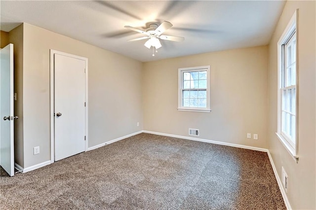 unfurnished room with ceiling fan and carpet flooring