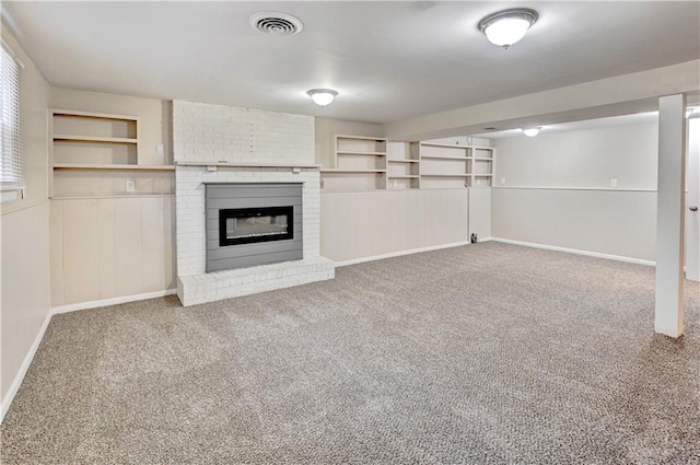 unfurnished living room with a brick fireplace and carpet