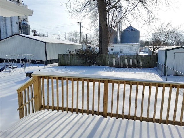 snow covered deck with a shed