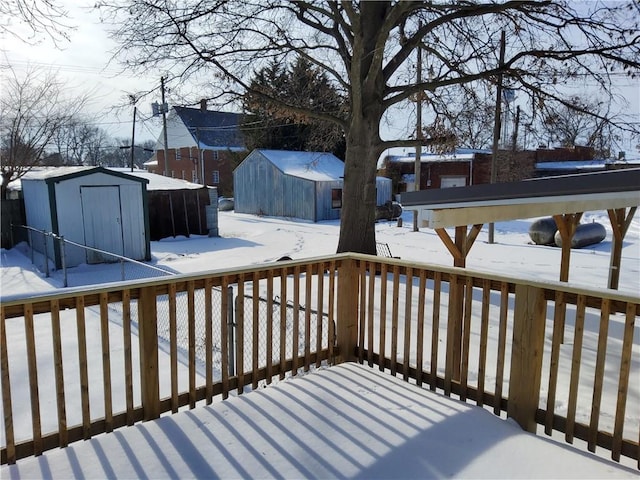 snow covered deck with a shed