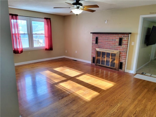 unfurnished living room with ceiling fan, a fireplace, and hardwood / wood-style flooring