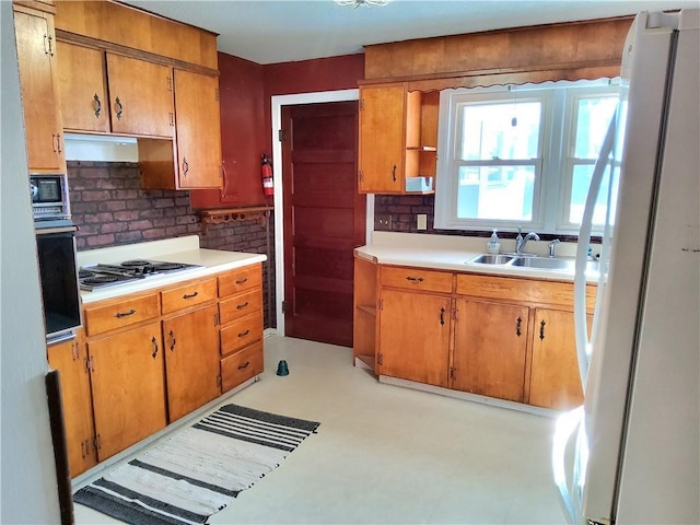 kitchen featuring white fridge, gas cooktop, wall oven, backsplash, and sink