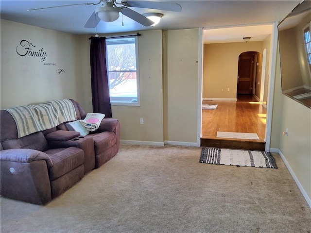 carpeted living room with ceiling fan