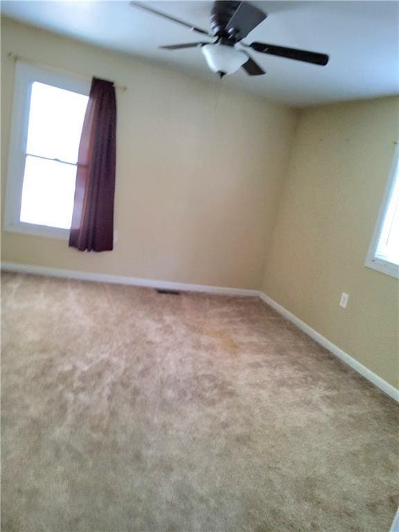 unfurnished room with ceiling fan and light colored carpet