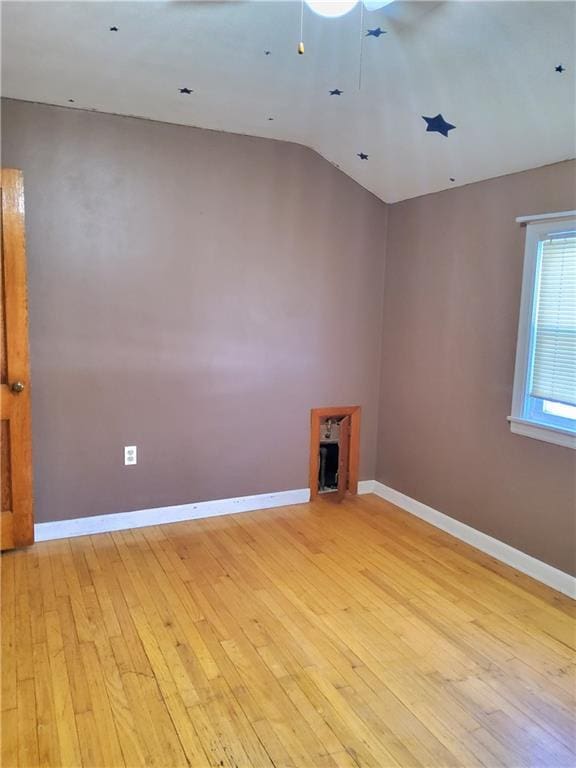 empty room featuring lofted ceiling, ceiling fan, and light hardwood / wood-style floors