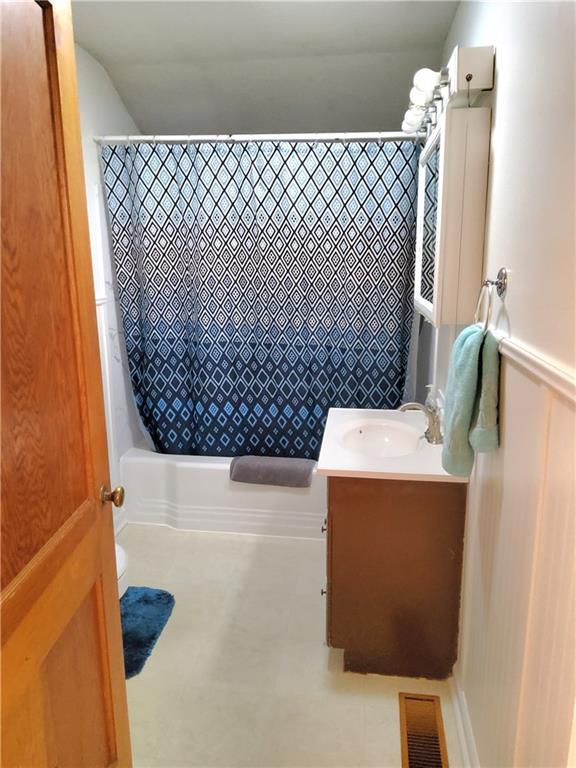 bathroom featuring vanity and shower / bath combo with shower curtain