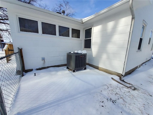 view of snow covered exterior featuring central AC unit