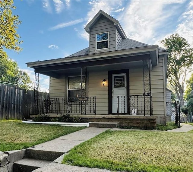 bungalow with covered porch and a front lawn