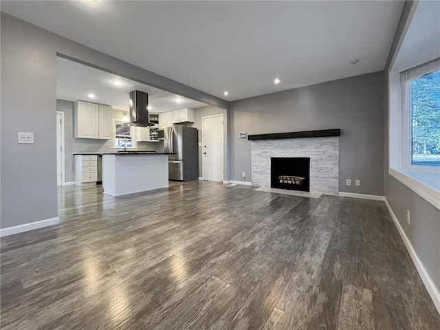 unfurnished living room with dark wood-type flooring and a fireplace