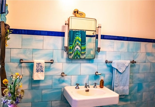 bathroom featuring sink and tile walls