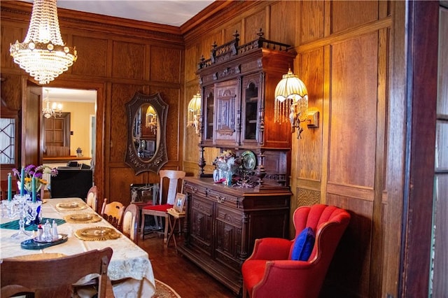 dining area featuring dark hardwood / wood-style flooring, ornamental molding, a chandelier, and wooden walls