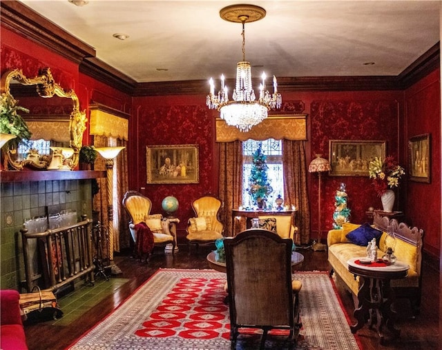 living area with crown molding, dark hardwood / wood-style floors, a tile fireplace, and a notable chandelier