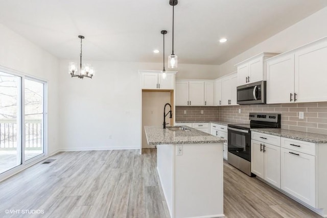 kitchen featuring sink, white cabinets, an island with sink, and appliances with stainless steel finishes