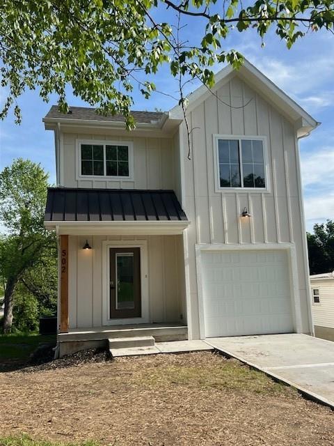 502 E Fair St, Independence, MO 64055 - view of front of property with a standing seam roof, an attached garage, concrete driveway, board and batten siding, and metal roof