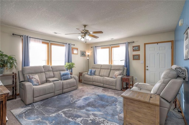 carpeted living room with ceiling fan and a textured ceiling