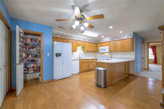 kitchen with sink, white appliances, ceiling fan, kitchen peninsula, and light wood-type flooring