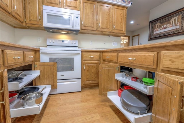 kitchen with white appliances and light hardwood / wood-style flooring