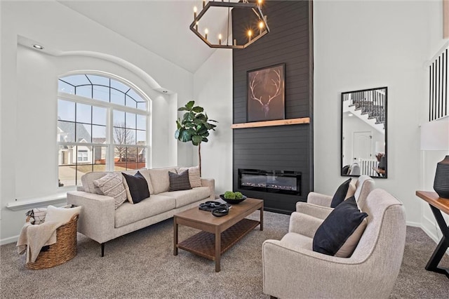 carpeted living area featuring a chandelier, high vaulted ceiling, a fireplace, and baseboards