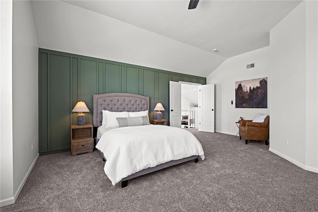 bedroom with visible vents, a decorative wall, carpet flooring, vaulted ceiling, and ceiling fan