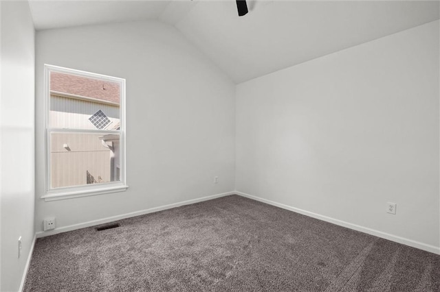 carpeted spare room featuring visible vents, vaulted ceiling, baseboards, and ceiling fan