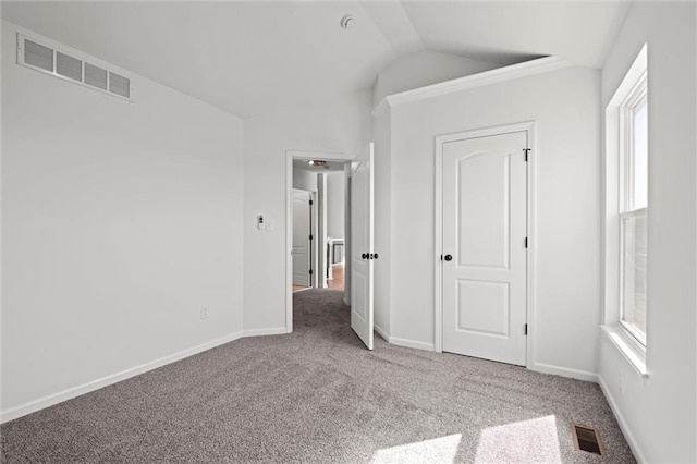 unfurnished bedroom with carpet, visible vents, and lofted ceiling