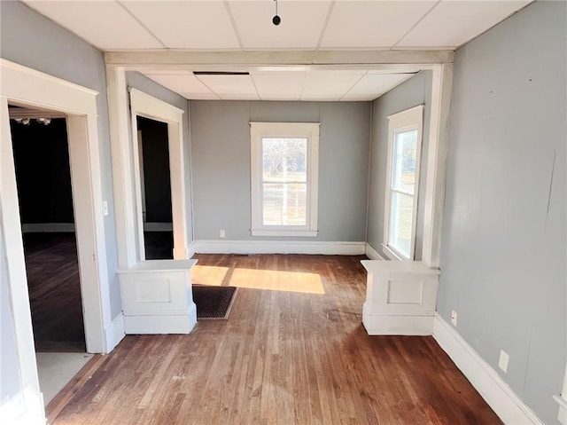 empty room featuring a paneled ceiling and hardwood / wood-style floors