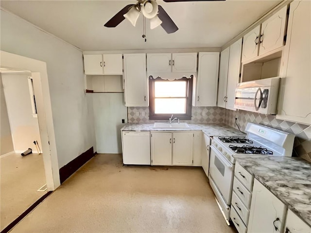 kitchen with white appliances, backsplash, white cabinets, ceiling fan, and sink