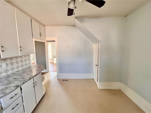 kitchen featuring ceiling fan, white cabinetry, and decorative backsplash