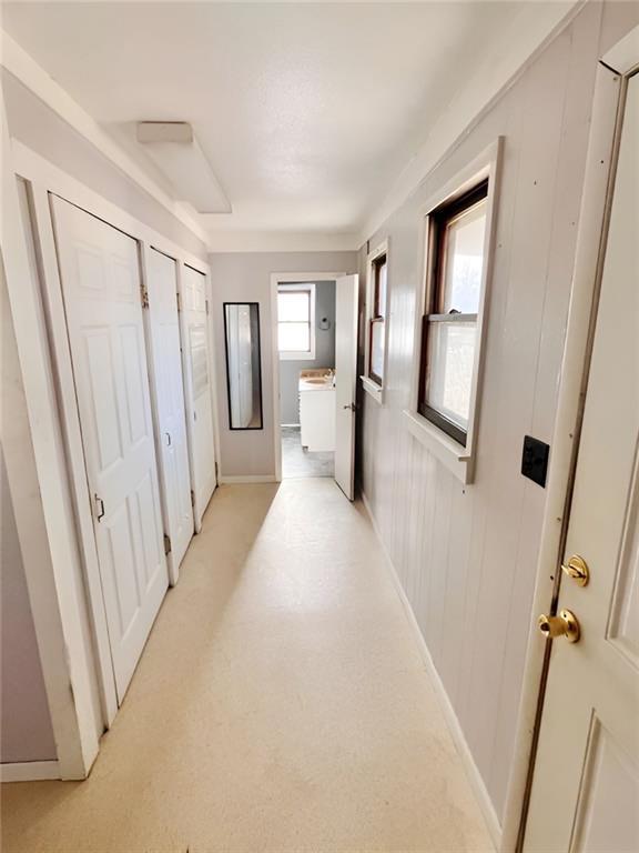 corridor with washer / dryer and wood walls