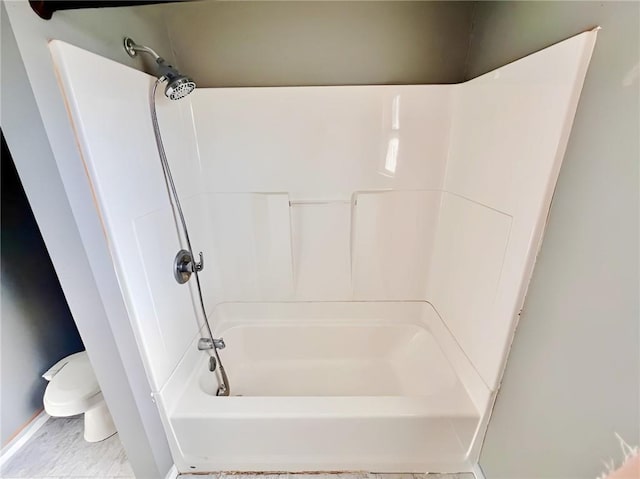 bathroom with toilet and washtub / shower combination