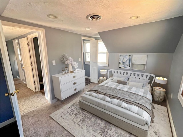 carpeted bedroom with lofted ceiling and a textured ceiling