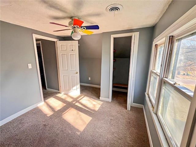 unfurnished bedroom featuring ceiling fan, light colored carpet, a closet, and a textured ceiling