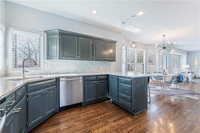 kitchen featuring dark wood-type flooring, sink, decorative light fixtures, dishwasher, and kitchen peninsula