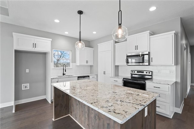 kitchen featuring a center island, stainless steel appliances, decorative backsplash, white cabinetry, and sink