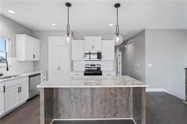 kitchen featuring sink, stainless steel appliances, white cabinets, and a kitchen island