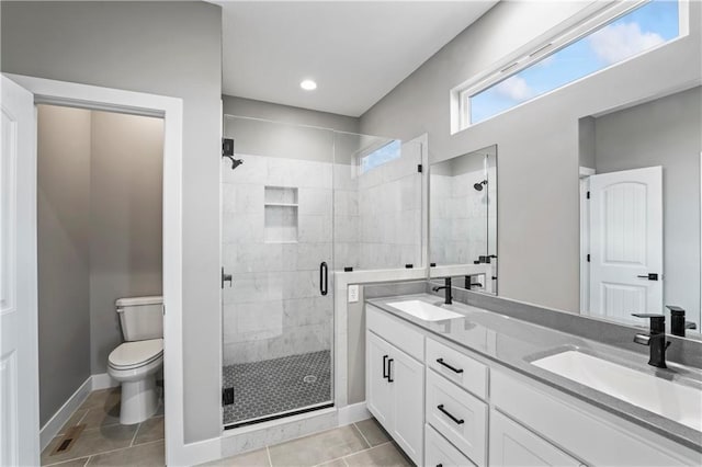 bathroom with toilet, tile patterned flooring, vanity, and a shower with shower door