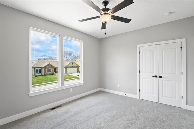 unfurnished bedroom with ceiling fan, a closet, and carpet