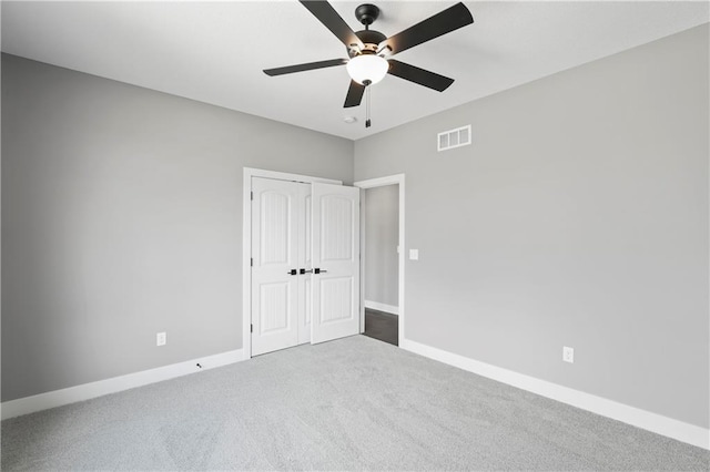 unfurnished bedroom with ceiling fan, a closet, and carpet