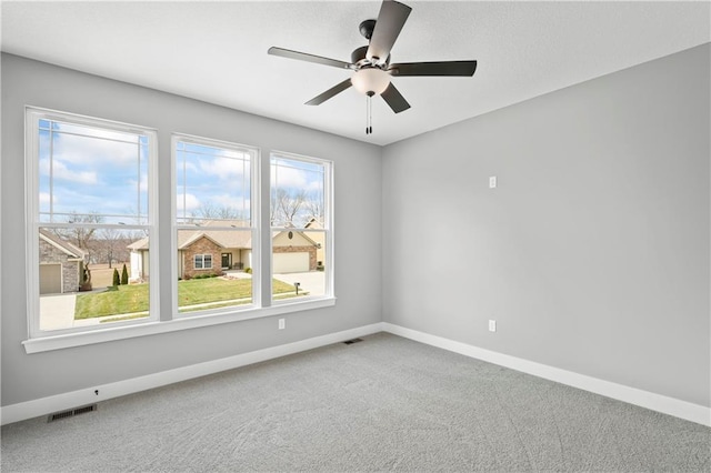 spare room with ceiling fan and carpet