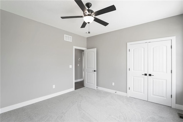 unfurnished bedroom featuring ceiling fan, a closet, and light carpet