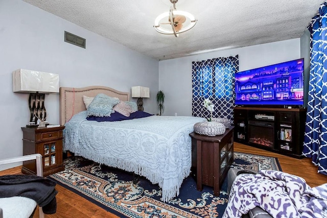 bedroom featuring a textured ceiling and hardwood / wood-style floors