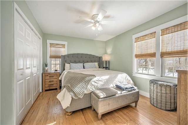 bedroom featuring ceiling fan, light wood-type flooring, and a closet