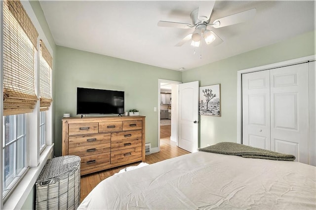 bedroom featuring ceiling fan, a closet, and light hardwood / wood-style floors