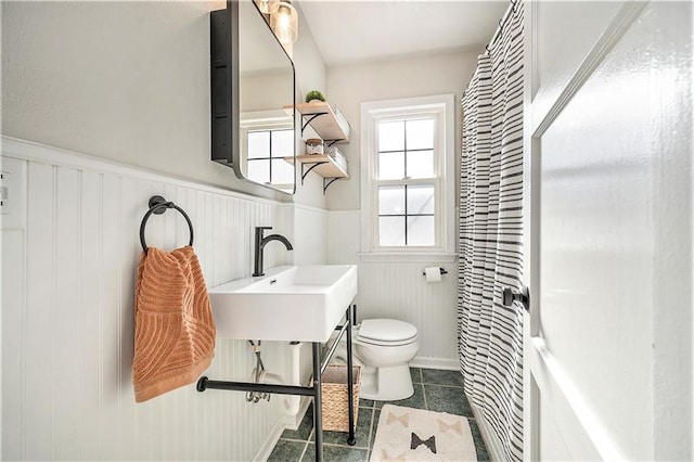 bathroom with toilet, tile patterned flooring, and sink