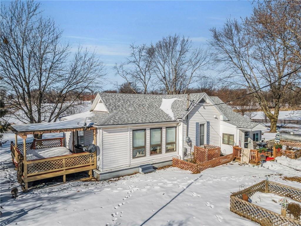 snow covered rear of property with a wooden deck