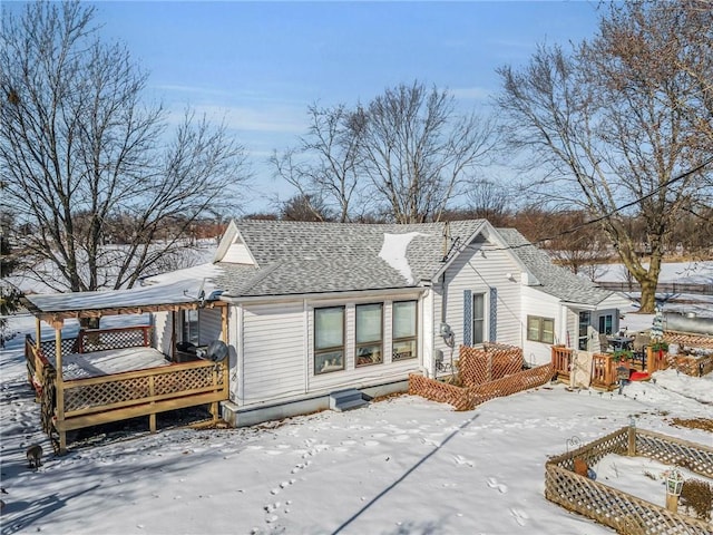 snow covered rear of property with a wooden deck