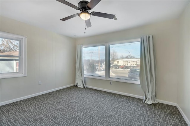 carpeted empty room featuring ceiling fan and plenty of natural light