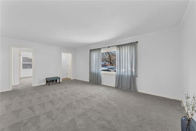 carpeted spare room featuring crown molding