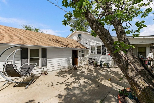 back of house featuring roof with shingles and a patio