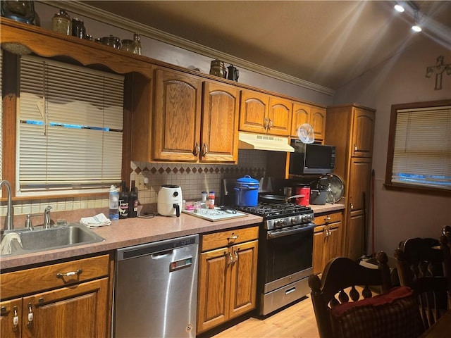 38708 E Hudson Rd, Oak Grove, MO 64075 - kitchen featuring appliances with stainless steel finishes, under cabinet range hood, brown cabinets, crown molding, and lofted ceiling
